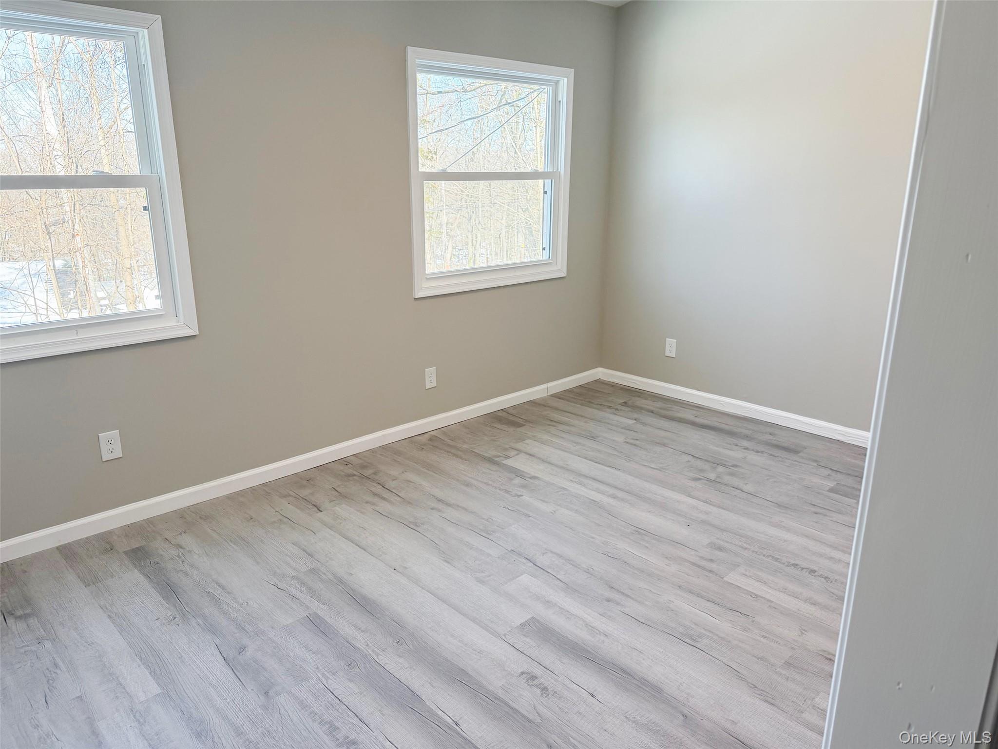 9 Underhill Trail Monroe, NY 10950 - Photo 10 of 18 an empty room with wooden floor and windows