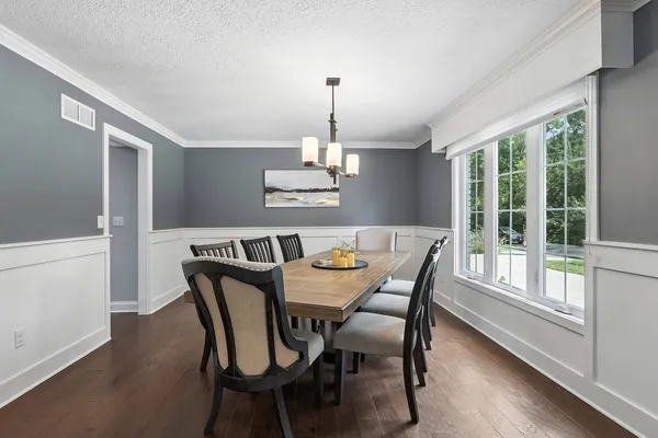a dining room with furniture window and wooden floor