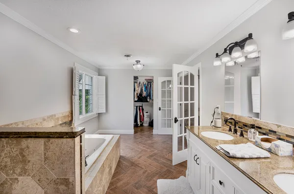 a spacious bathroom with a granite countertop sink a mirror and a shower