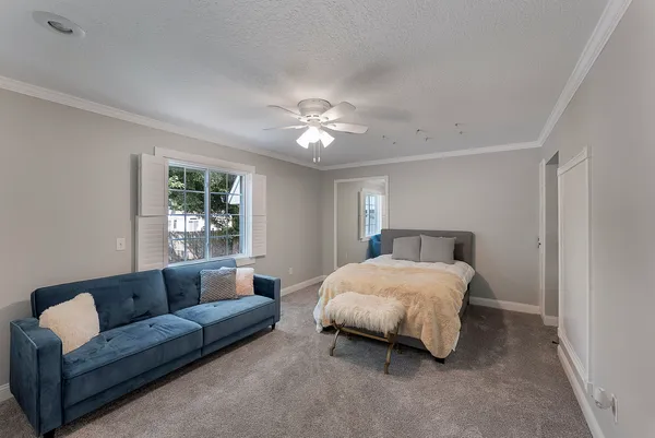 a bedroom with a bed couch chandelier and window