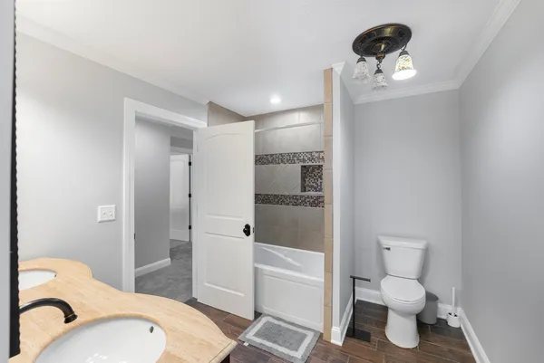 a bathroom with a toilet sink a mirror and shower