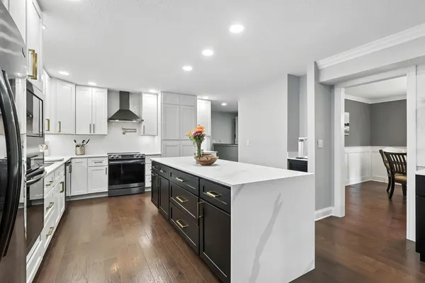 a kitchen with a white stove a sink and a refrigerator