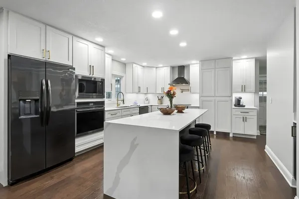 a kitchen with refrigerator cabinets and wooden floor