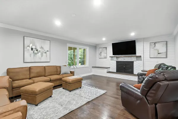 a living room with furniture a flat screen tv and a fireplace