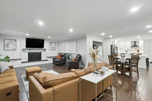 a living room with furniture a flat screen tv and kitchen view