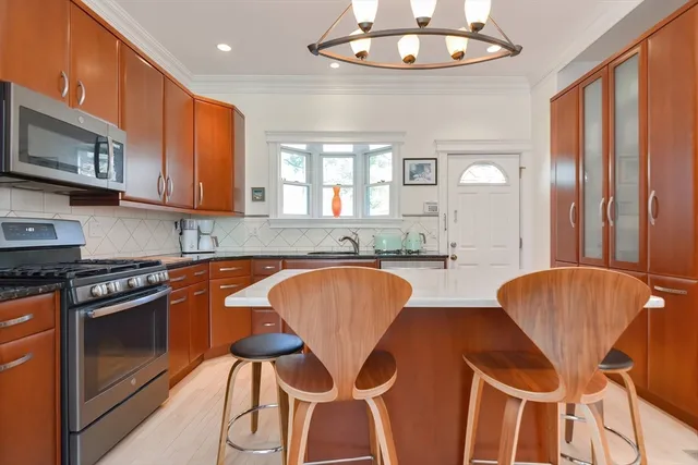 a kitchen with stainless steel appliances granite countertop a stove a sink and a microwave