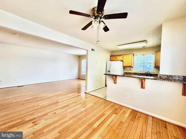 a view of a kitchen with wooden floor and a ceiling fan