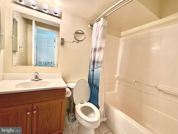 a bathroom with a granite countertop toilet sink and mirror