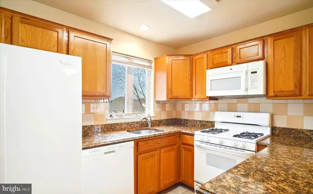 a kitchen with granite countertop a sink and a stove top oven