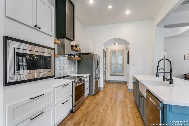 a kitchen with stainless steel appliances a stove sink and cabinets