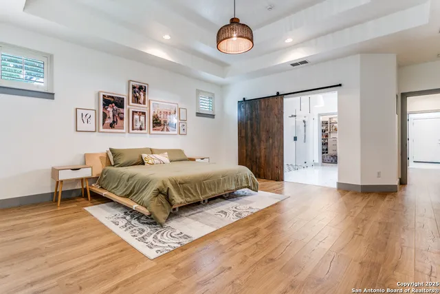 a spacious bedroom with a bed and a chandelier
