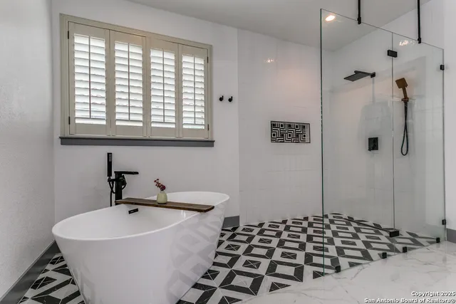 a bathroom with a sink a window and a shower