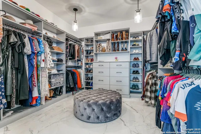 a view of walk in closet with clothes and shoes