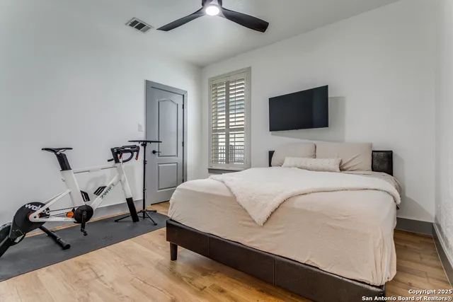 a bedroom with a bed a flat screen tv and a chandelier