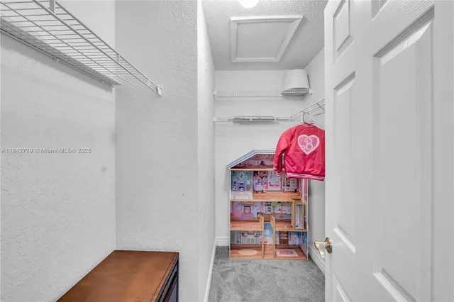 a bed sitting in a spacious bedroom next to a window