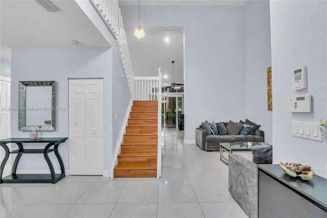 a view of a dining room with furniture a chandelier and wooden floor