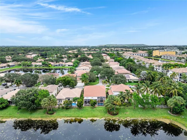 an aerial view of residential houses with outdoor space and trees