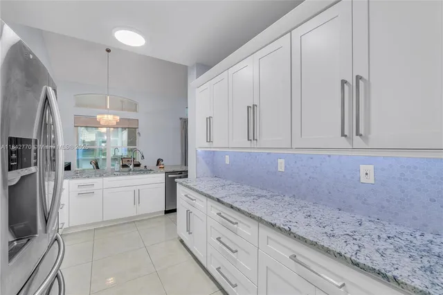 a kitchen with white cabinets and sink