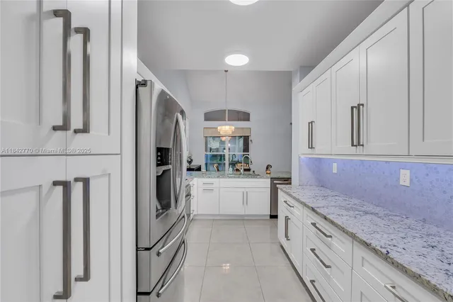 a kitchen with granite countertop white cabinets and white appliances