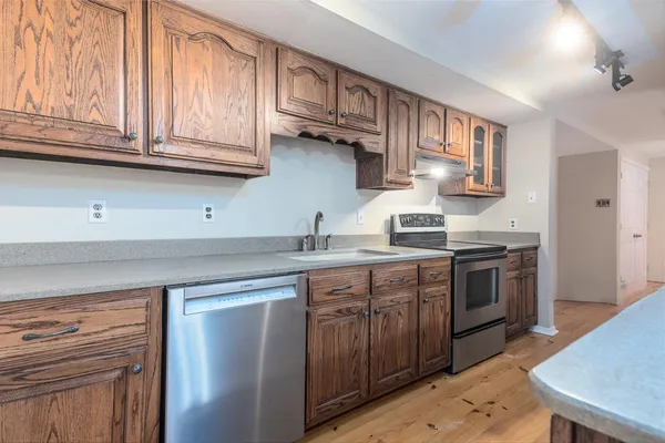a kitchen with stainless steel appliances granite countertop a sink dishwasher stove and cabinets