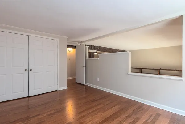 a view of an empty room with wooden floor