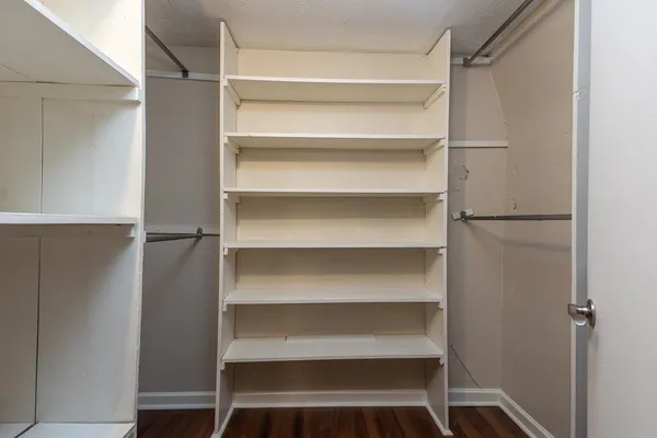 a view of walk in closet with empty racks