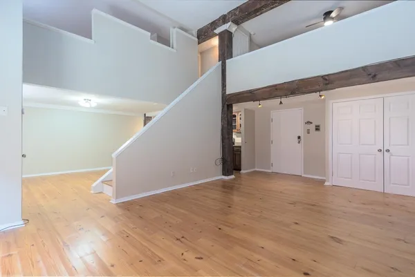 a view of an empty room with wooden floor