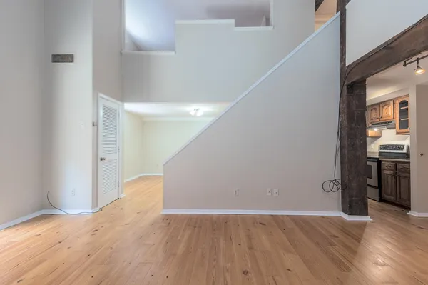 a view of an empty room with window and wooden floor