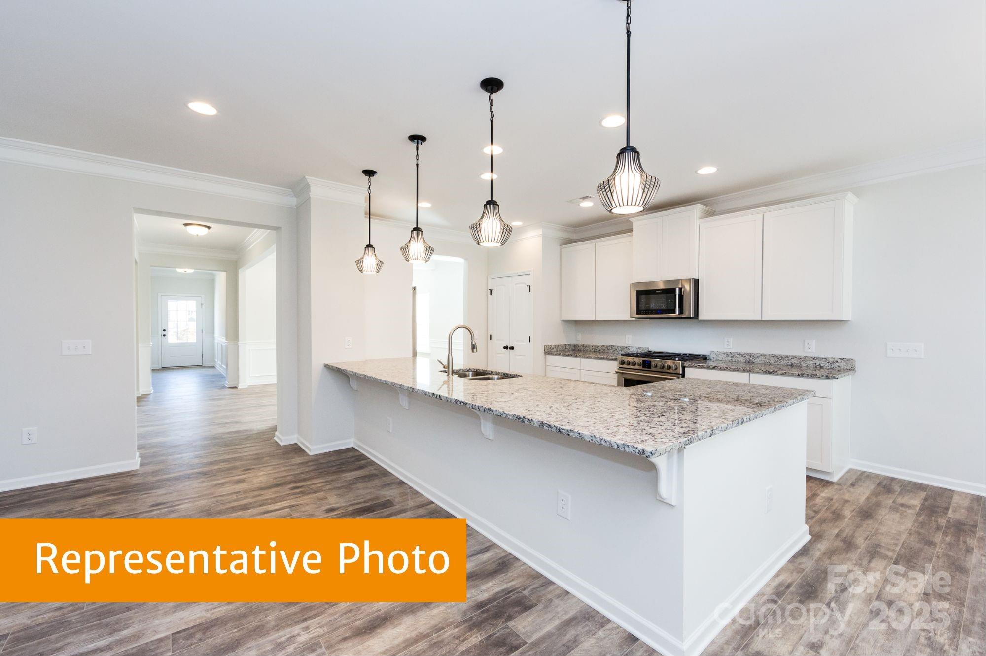 12155 Muscadine Court Midland, NC 28107 - Photo 2 of 20 a large kitchen with granite countertop a sink a counter space and stainless steel appliances