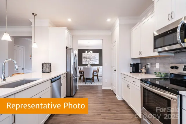 a view of kitchen with stainless steel appliances granite countertop a sink and cabinets