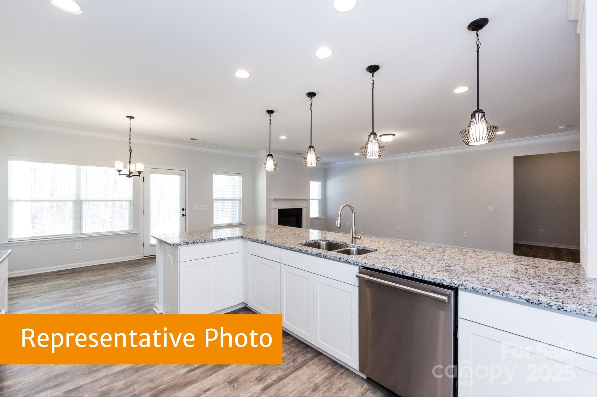 12155 Muscadine Court Midland, NC 28107 - Photo 5 of 20 a kitchen with kitchen island granite countertop a sink a counter top space and cabinets