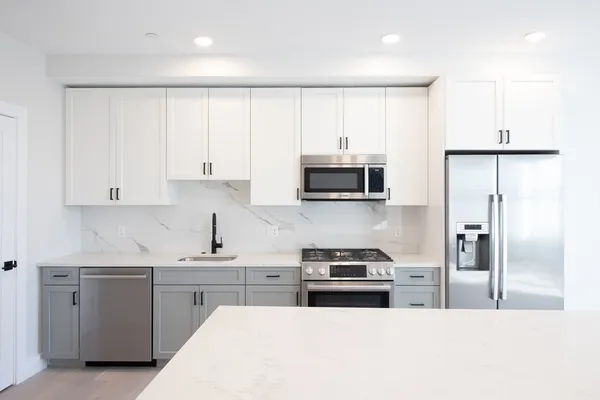 a kitchen with white cabinets and stainless steel appliances