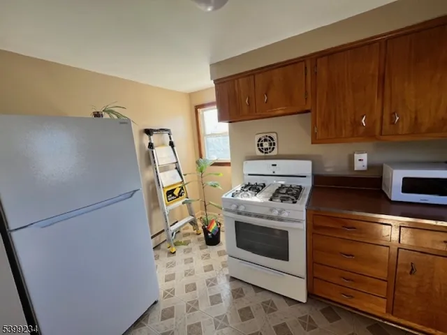 a kitchen with a stove top oven and refrigerator