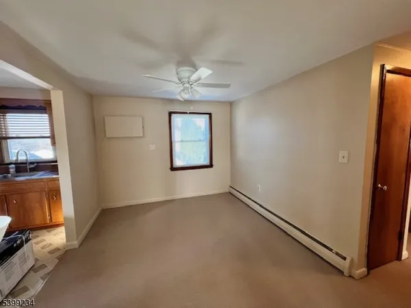 an empty room with windows and cabinet
