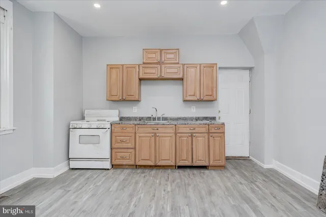 a kitchen with granite countertop white cabinets and white appliances