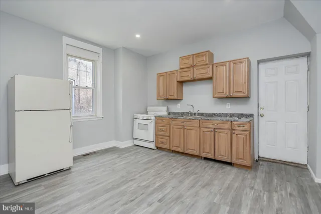 a kitchen with granite countertop white cabinets and white appliances