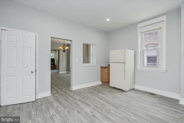 an empty room with wooden floor and cabinet