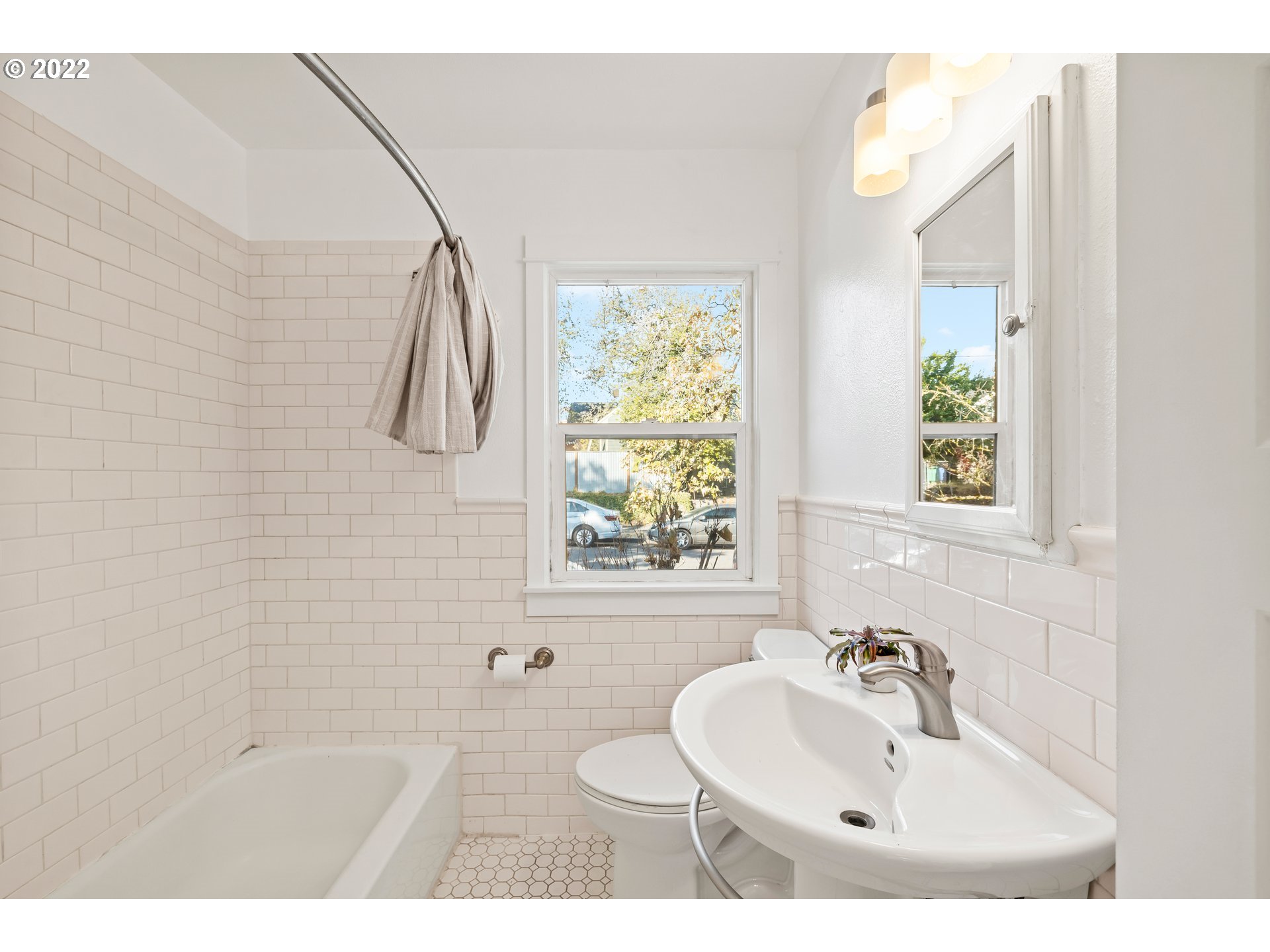 506 Northeast Rosa Parks Way, Unit 2 Portland, OR 97211 - Photo 7 of 17 a bathroom with a sink toilet a mirror and shower