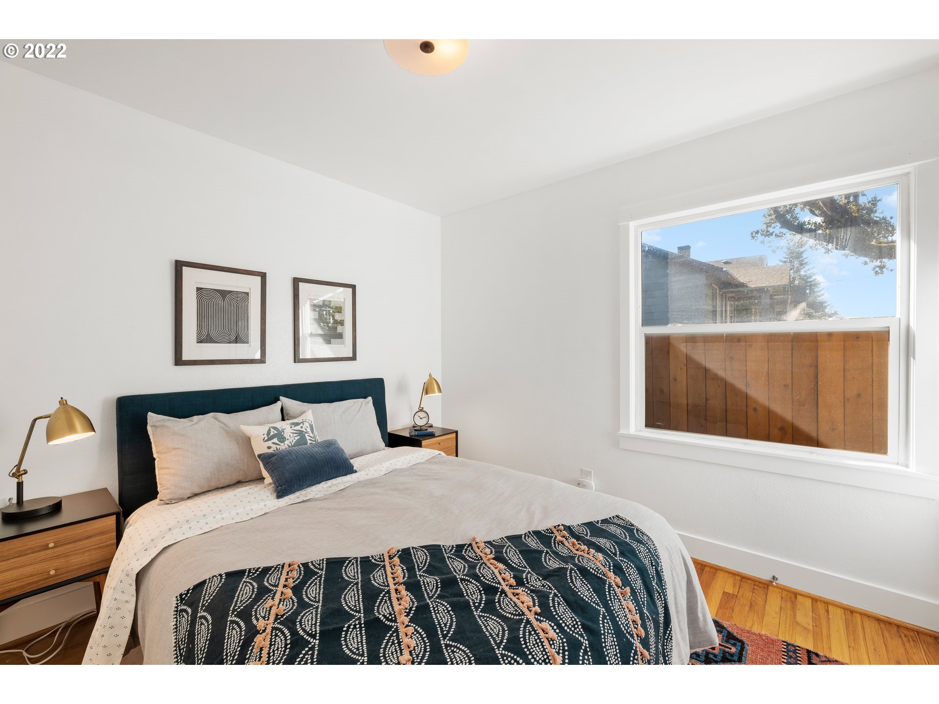 506 Northeast Rosa Parks Way, Unit 2 Portland, OR 97211 - Photo 8 of 17 a bedroom with a bed and a painting on the wall