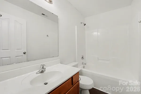 a bathroom with a sink a toilet and a large mirror