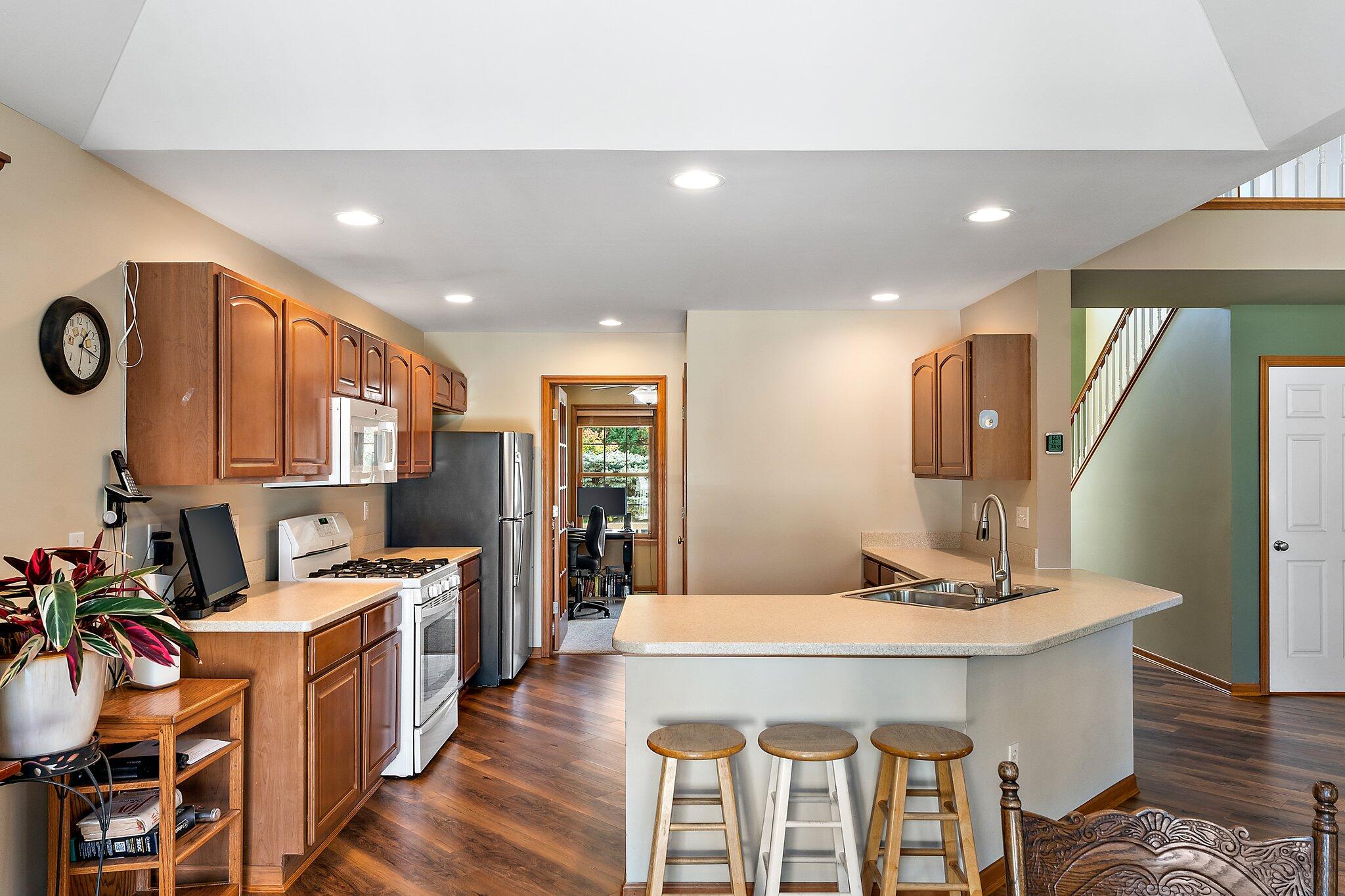 1636 Edith Way Crown Point, IN 46307 - Photo 18 of 56 a kitchen with stainless steel appliances kitchen island granite countertop a refrigerator a stove a sink and a dining table with wooden floor