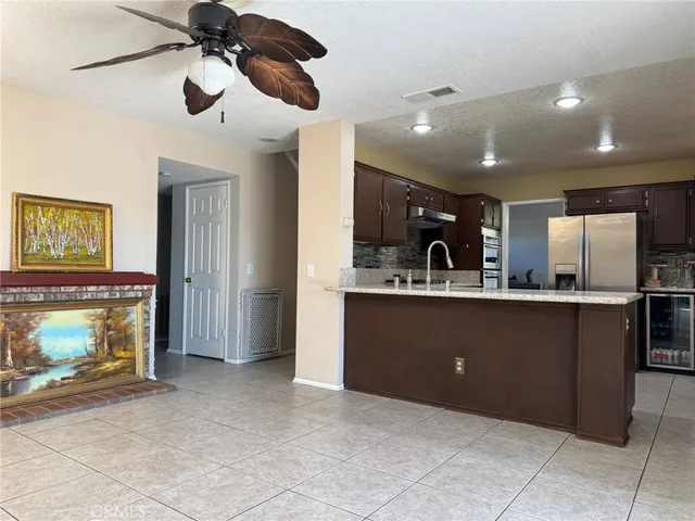a kitchen with kitchen island a counter top space appliances and a ceiling fan