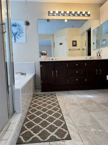 a spacious bathroom with a bathtub sink and mirror