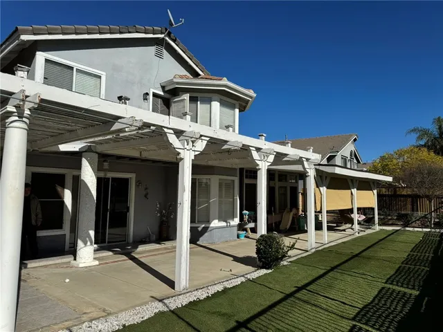 a view of a white house with large windows and a table