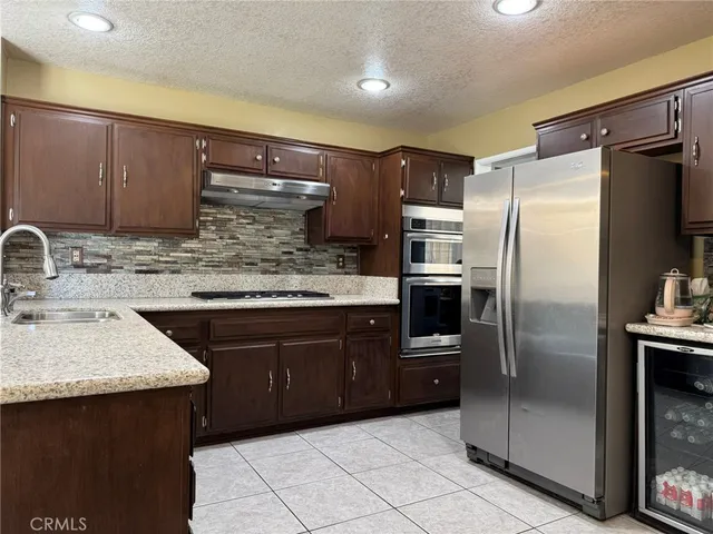 a kitchen with granite countertop a refrigerator and a sink