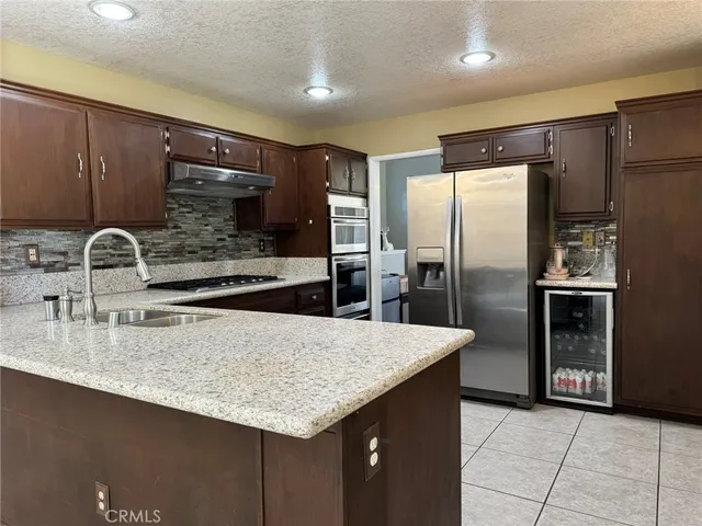 a kitchen with stainless steel appliances granite countertop a sink and a refrigerator