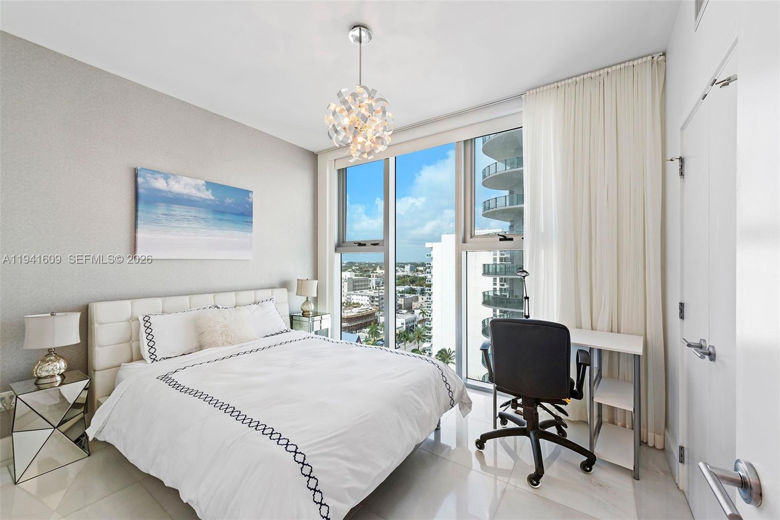 6899 Collins Avenue, Unit 1205 Miami Beach, FL 33141 - Photo 15 of 48 a bedroom with a bed and a chandelier
