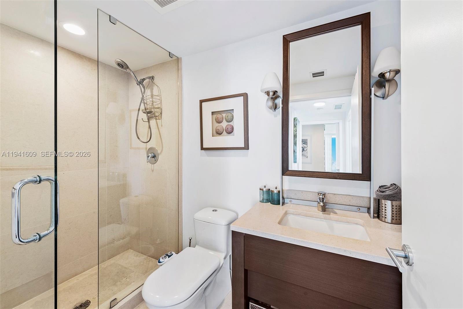 6899 Collins Avenue, Unit 1205 Miami Beach, FL 33141 - Photo 17 of 48 a bathroom with a sink vanity mirror and toilet