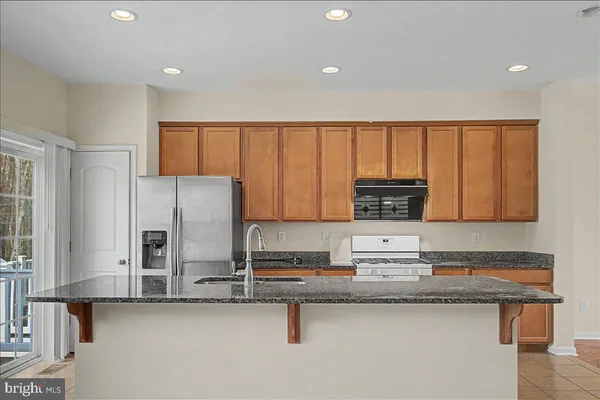 a kitchen with stainless steel appliances granite countertop a refrigerator and a stove
