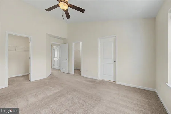 an empty room with chandelier fan